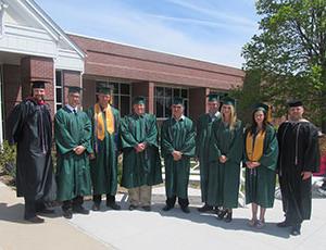 Veteran and military students and staff celebrate with a photo after graduation